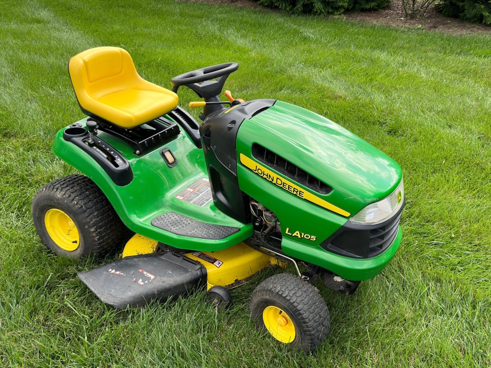 a green lawn mower sitting on top of a lush green field