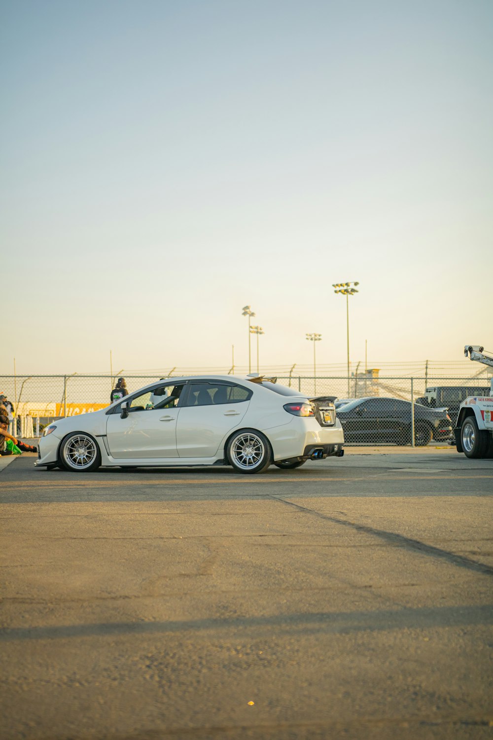 a white car is parked in a parking lot