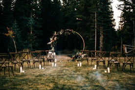 A beautifully decorated outdoor wedding setup with elegant floral arrangements and soft lighting.