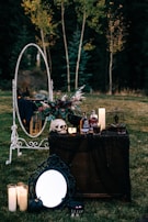 A vintage wooden table set with cobweb-covered plates and eerie skull-shaped mugs.