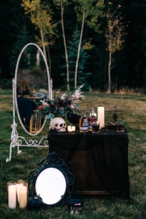 A vintage wooden table set with cobweb-covered plates and eerie skull-shaped mugs.