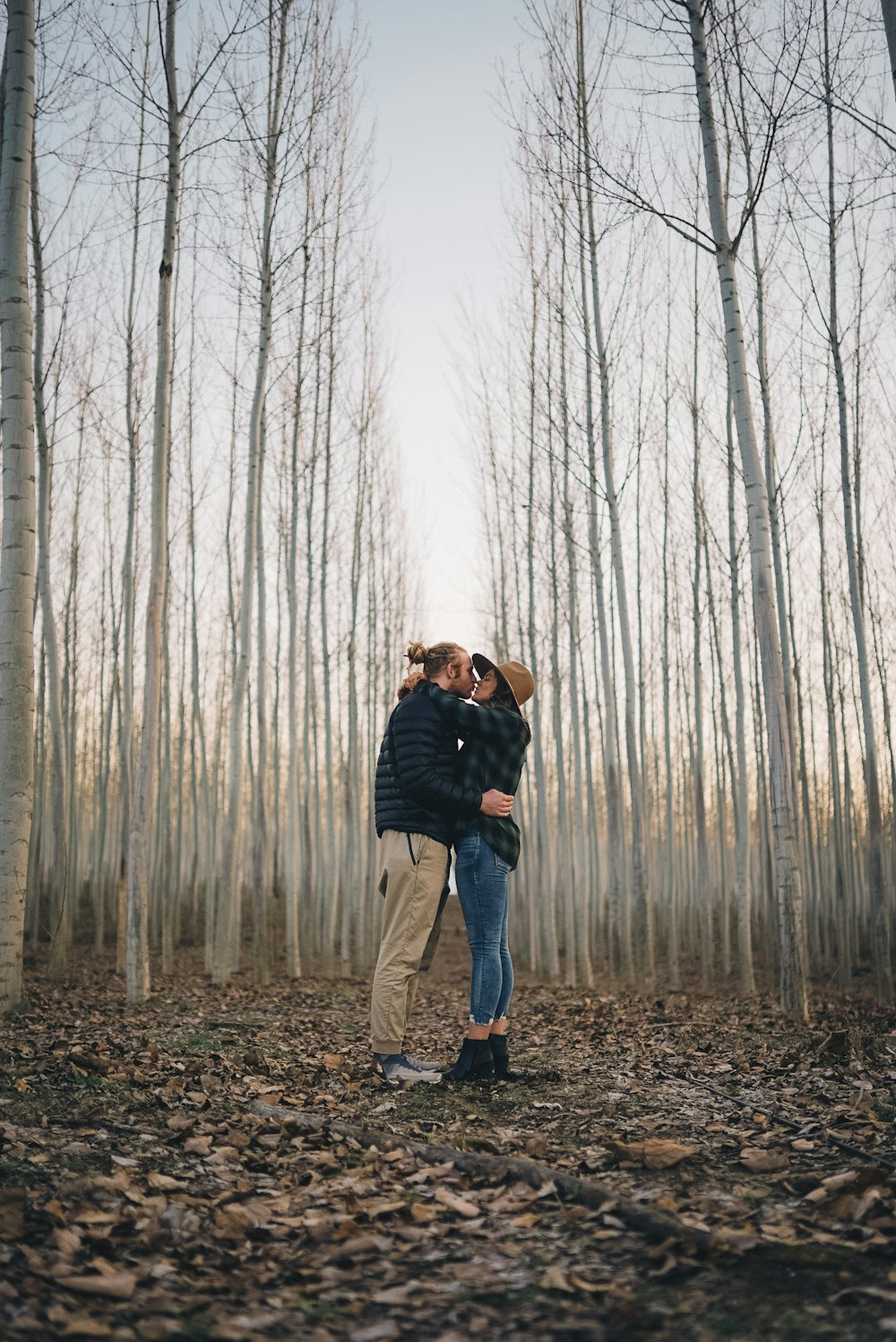 a man and woman kissing in the woods