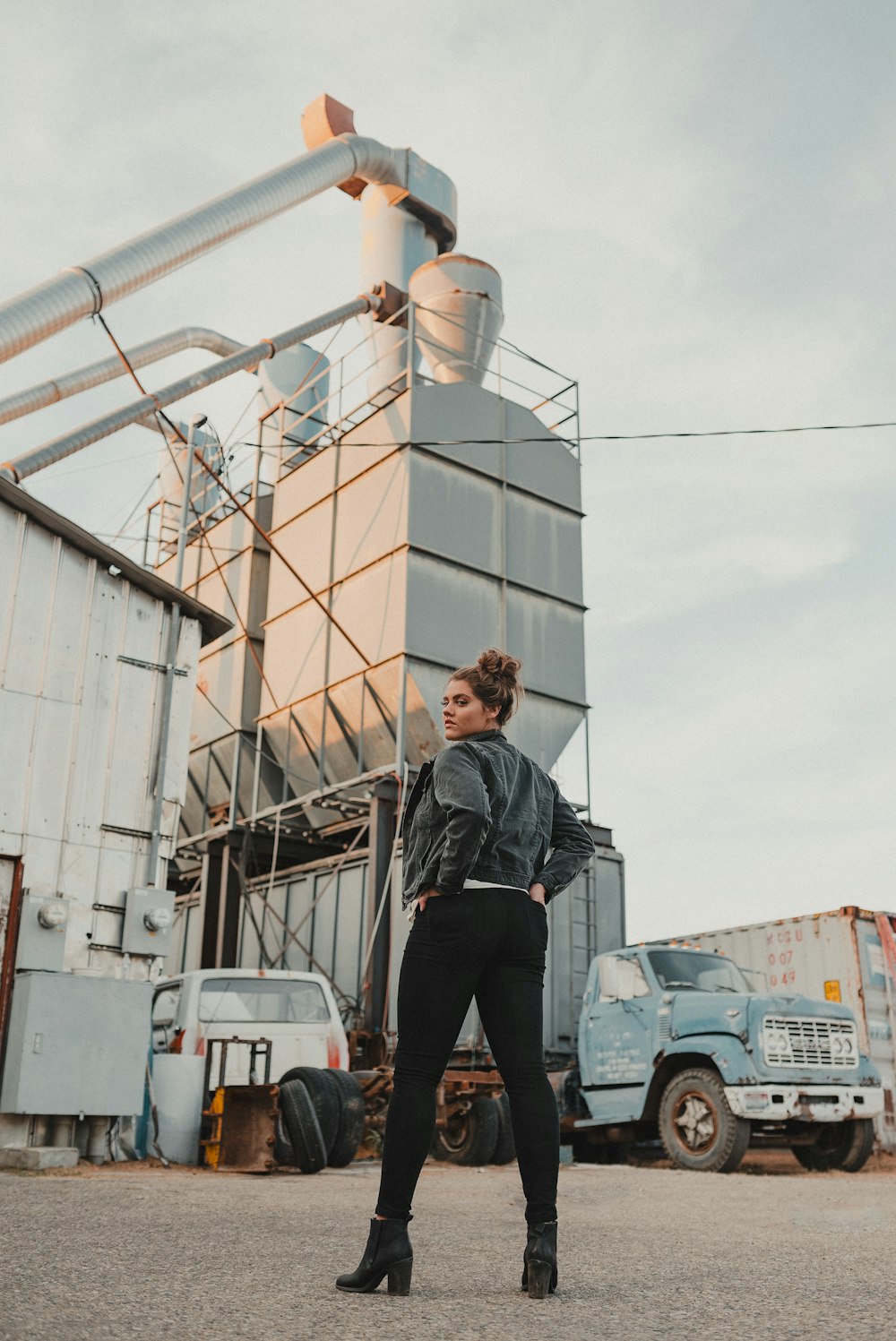 a woman standing in front of a large industrial building