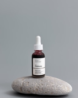 a bottle of vitamin oil sitting on top of a rock