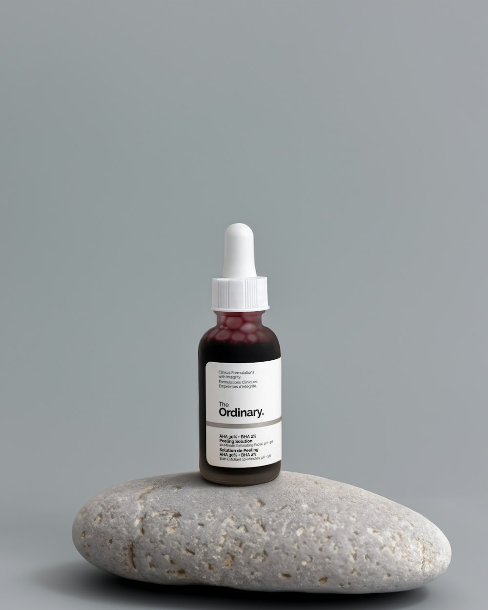 a bottle of vitamin oil sitting on top of a rock