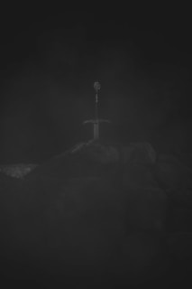 A dramatic shot of a legendary axe resting against ancient stone ruins, evoking timeless stories.