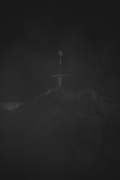 A glowing sword stuck in stone with mysterious runes illuminating the night
