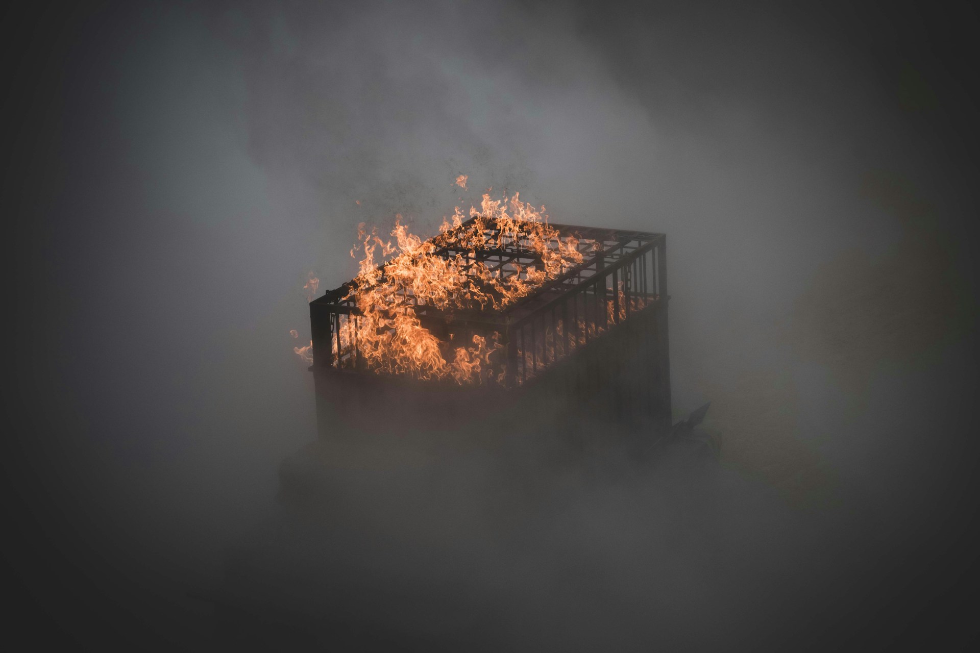 a burning crate in the middle of a foggy field