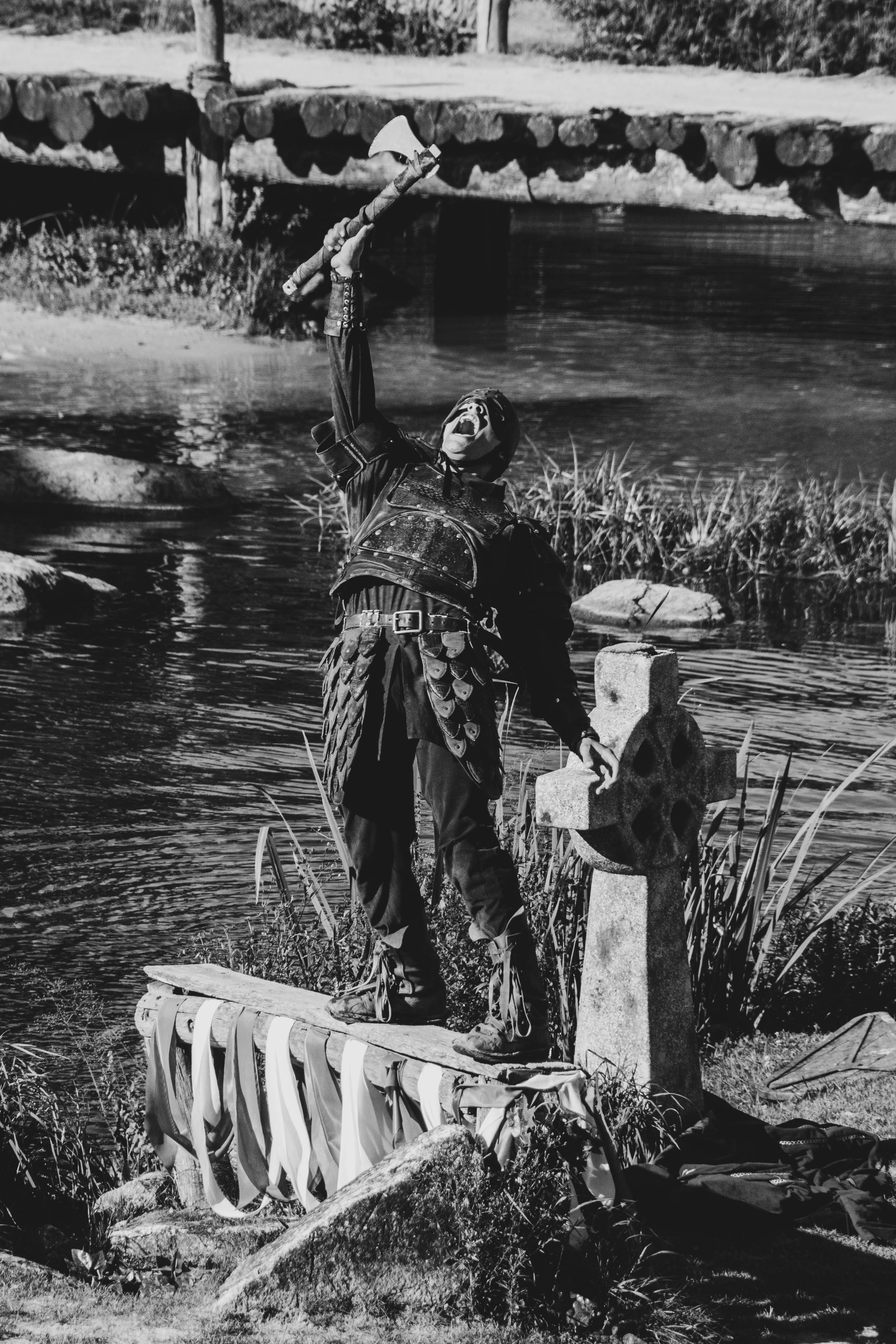 A black and white photo of a man standing next to a body of water photo ...