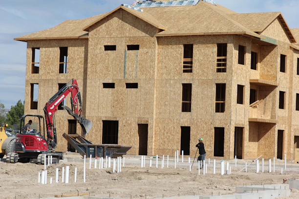 Construction site with workers building a residential house frame.