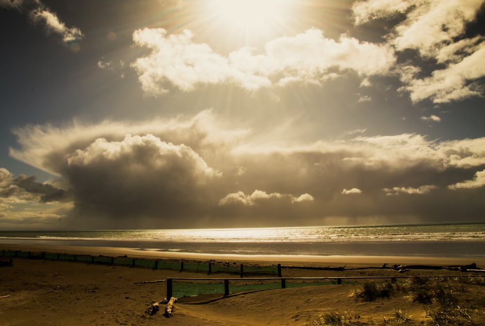 the sun is shining through the clouds over the beach