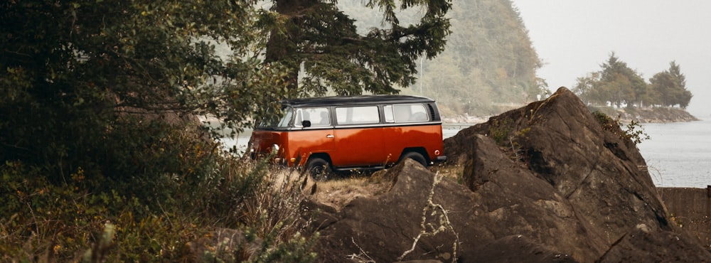 an orange and black van parked on top of a rock