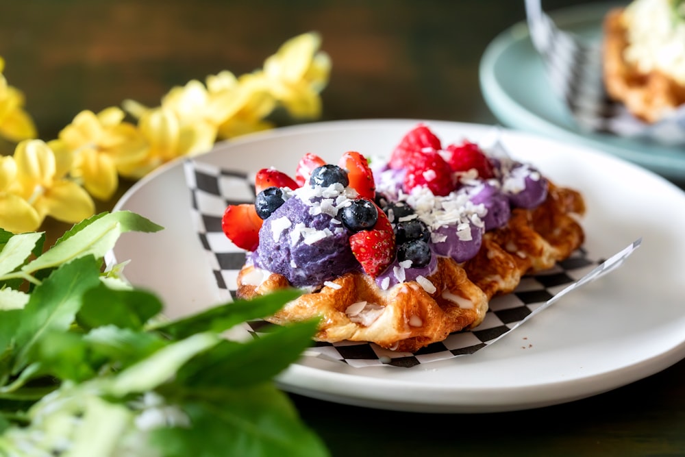 a white plate topped with waffles covered in fruit