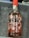 A bottle of Port Wine labeled 'DELAFORCE' with 'Rosé' below it is placed in a container filled with ice. The bottle has a red cap and is adorned with illustrations of various fruits such as cherries, watermelon slices, strawberries, oranges, and kiwis. There are visible liquid droplets on the bottle due to the cold ice.
