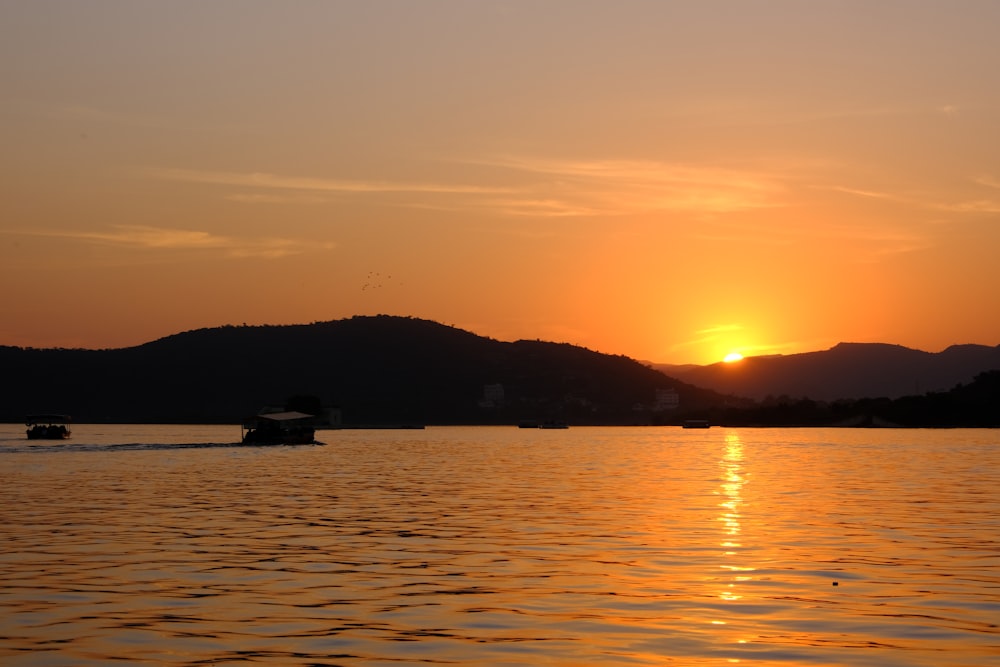 a sunset over a lake with boats in the water