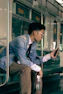 a man sitting on a train looking at his cell phone