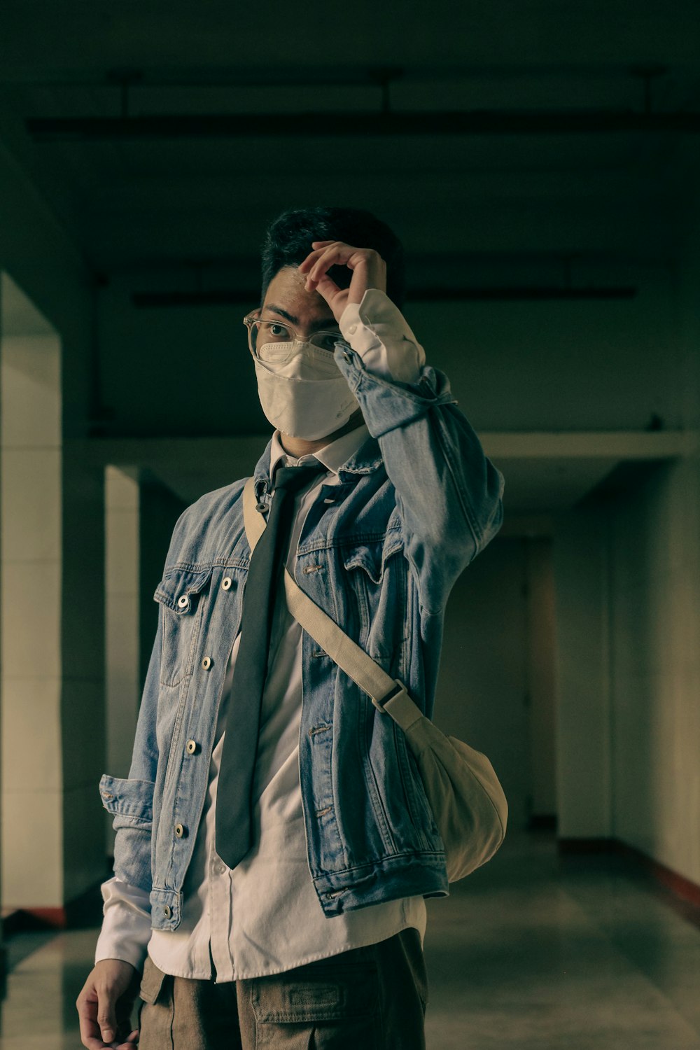 a man wearing a face mask and a denim jacket