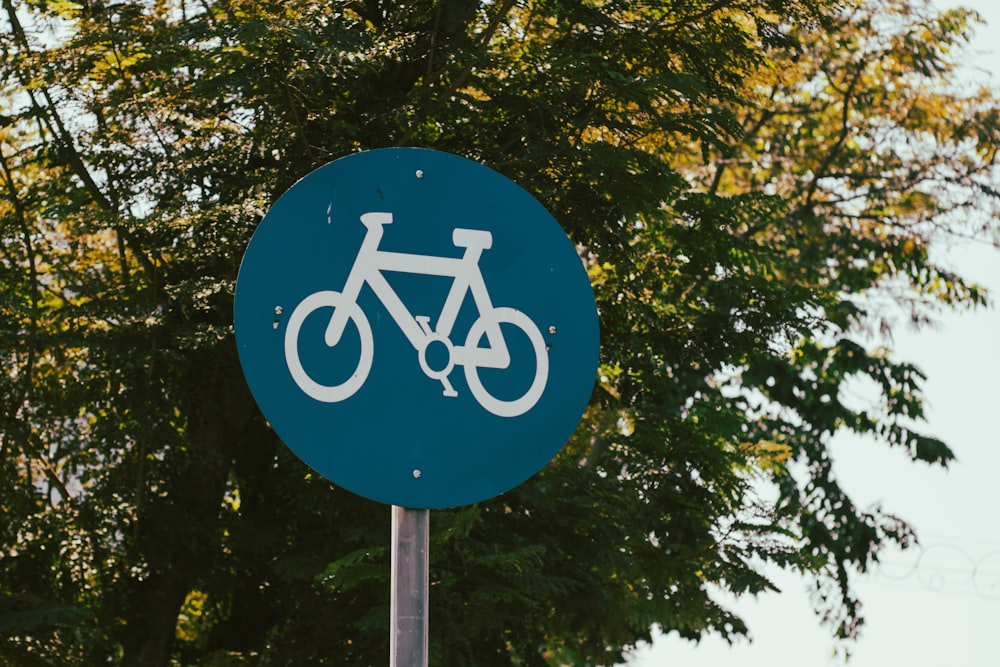 a blue street sign with a bicycle on it
