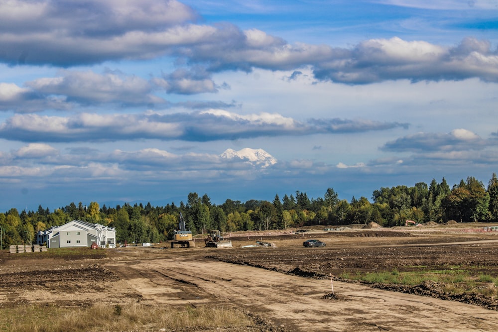 a dirt road in front of a farm