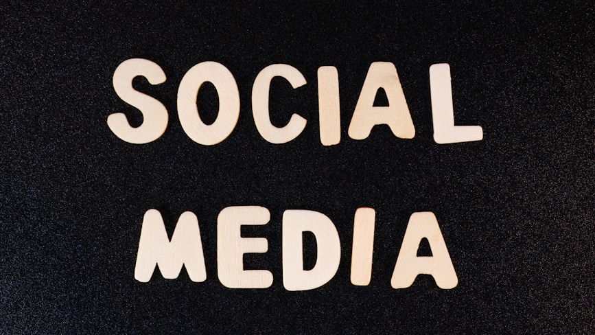 Block letters spelling 'SOCIAL MEDIA' arranged on a dark textured background.