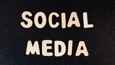 Block letters spelling 'SOCIAL MEDIA' arranged on a dark textured background.