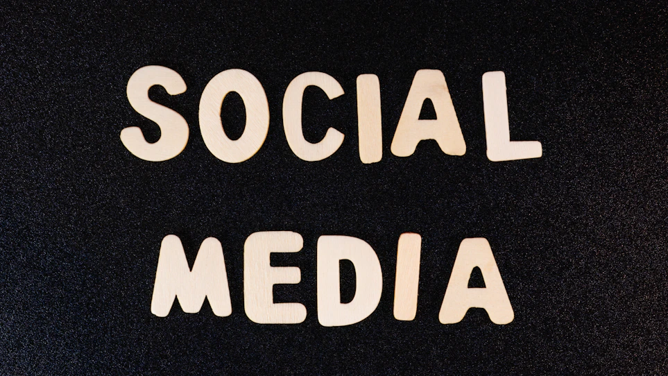 Block letters spelling 'SOCIAL MEDIA' arranged on a dark textured background.
