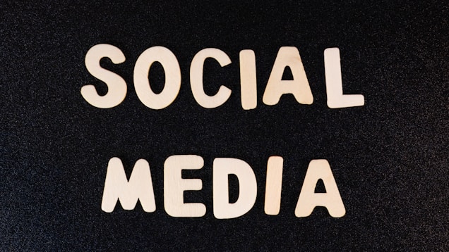 Block letters spelling 'SOCIAL MEDIA' arranged on a dark textured background.