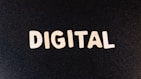 The word 'DIGITAL' is displayed in bold white letters against a plain black background.