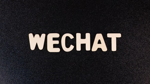 The word 'WECHAT' is written in bold, uppercase letters with a wooden texture against a dark background.