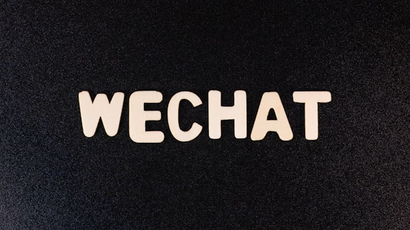 The word 'WECHAT' is written in bold, uppercase letters with a wooden texture against a dark background.