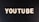 The word 'YOUTUBE' is displayed in white, bold, block letters against a black textured background.