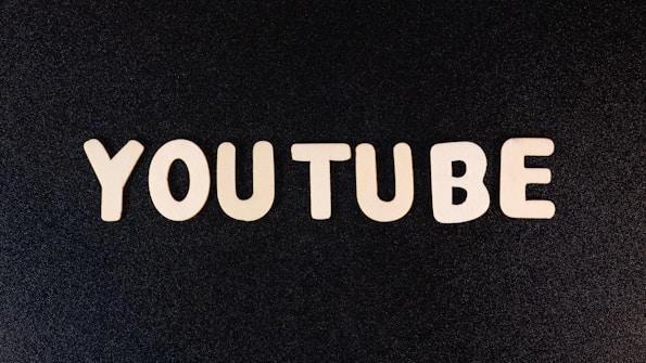 The word 'YOUTUBE' is displayed in white, bold, block letters against a black textured background.