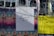A wall covered with various street art and event posters, including a central white poster with handwritten text that reads 'THIS IS THE RECORD OF THE TIME.' The surrounding posters feature colorful designs with details of events and artists, including Carl Craig's event in black text on a bright yellow background.