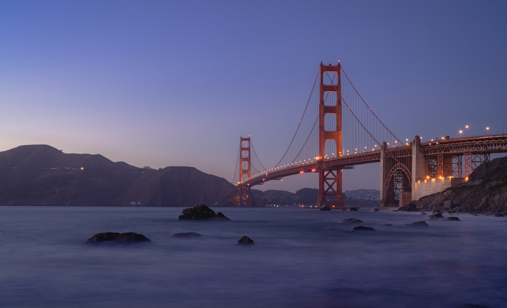 the golden gate bridge is lit up at night