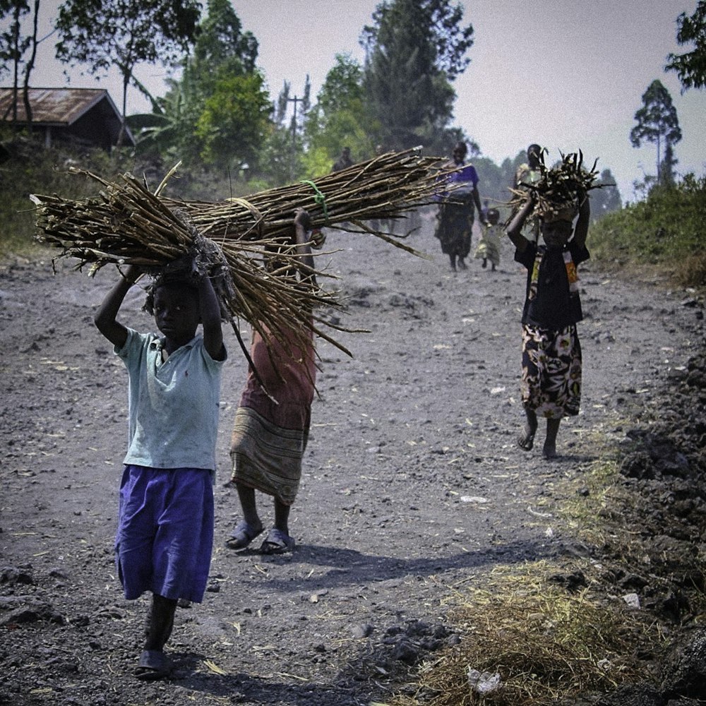 a group of people walking down a dirt road