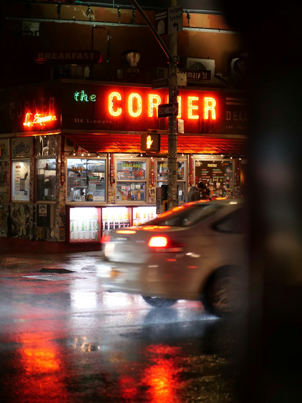 a car driving down a wet street at night