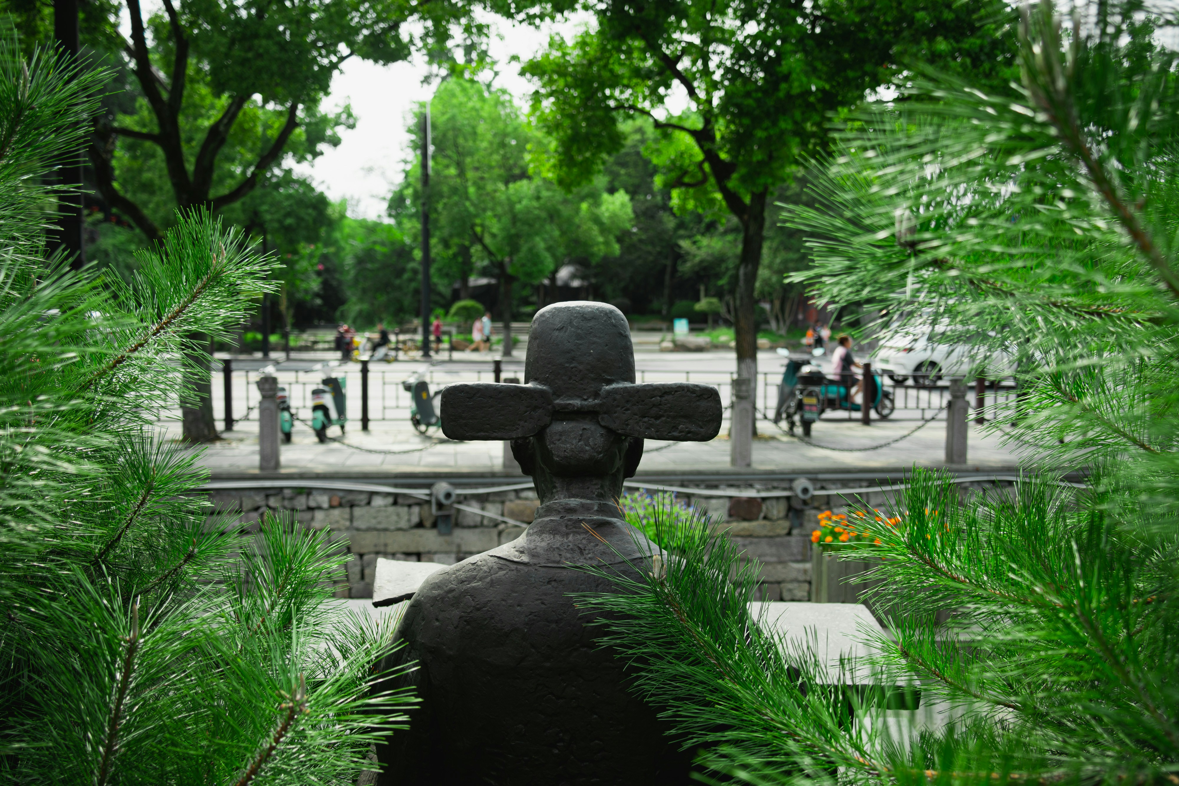 a statue of a cross in the middle of a park