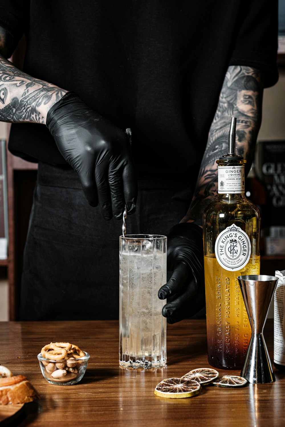 a man in black gloves and black gloves is making a drink