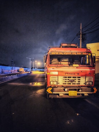 Nighttime shot of a water tanker truck illuminated by streetlights, highlighting 24-hour service.