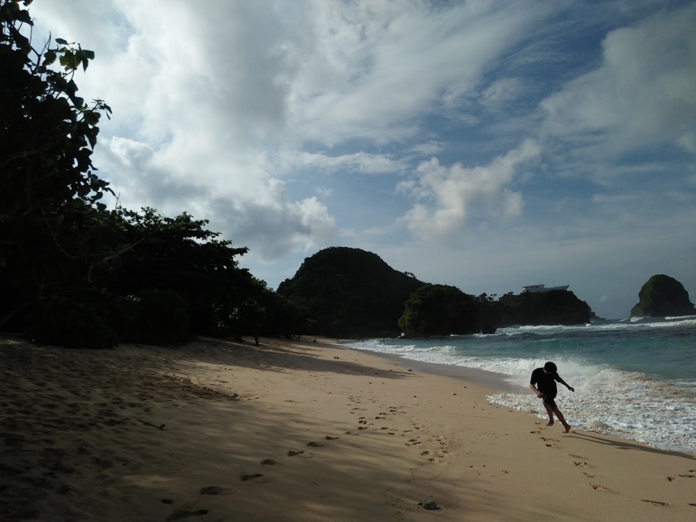 a person walking on a beach near the ocean