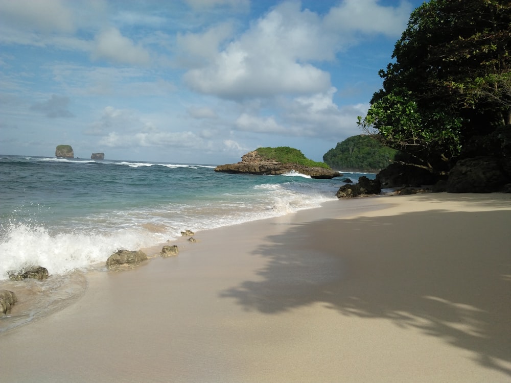 a sandy beach with waves coming in to shore