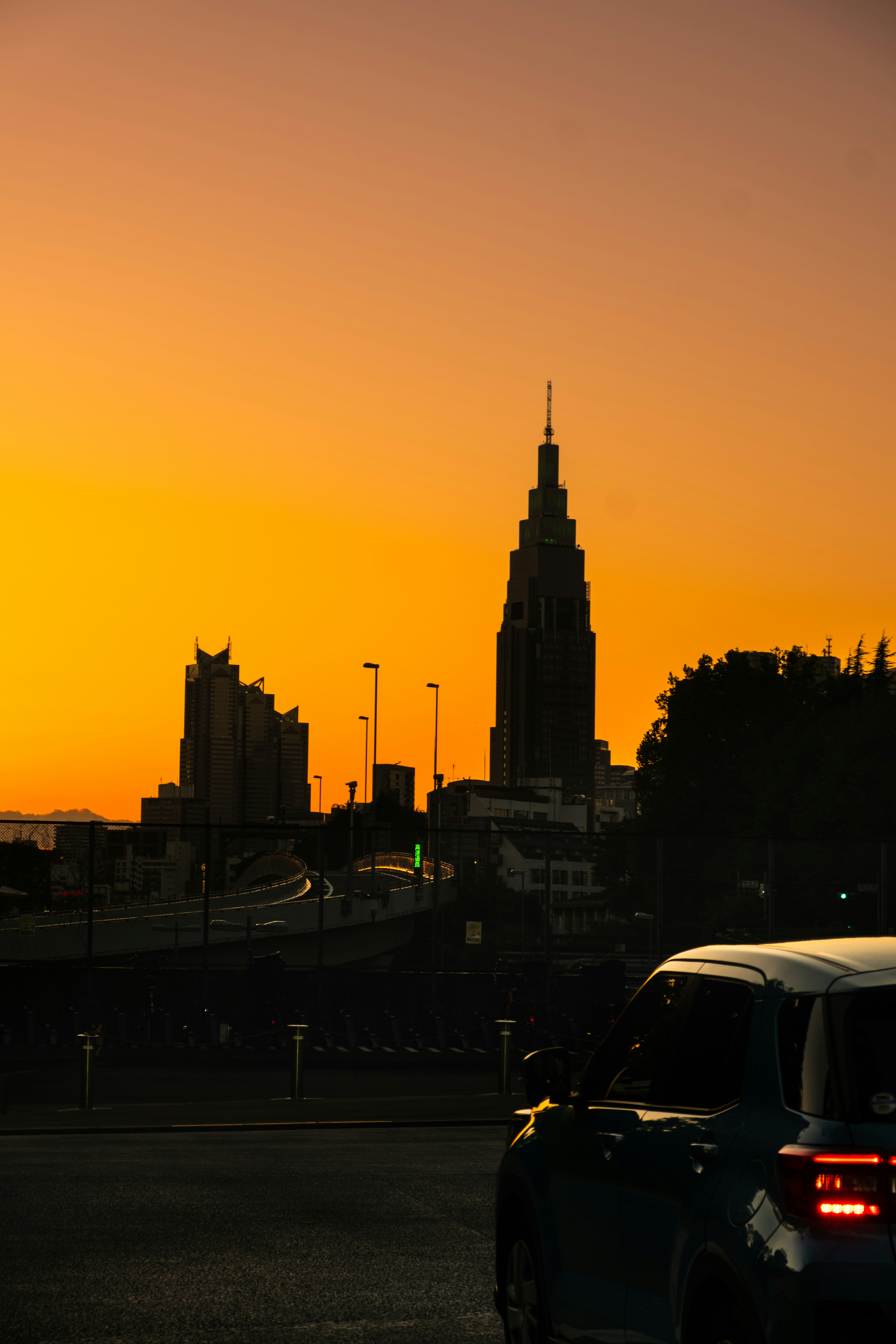 un coche conduciendo por una calle junto a un edificio alto