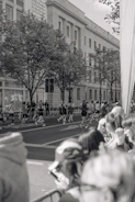 Runners in black and red gear training together on a city street at dawn