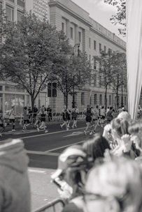 Runners crossing the start line of a street race in a vibrant city setting.