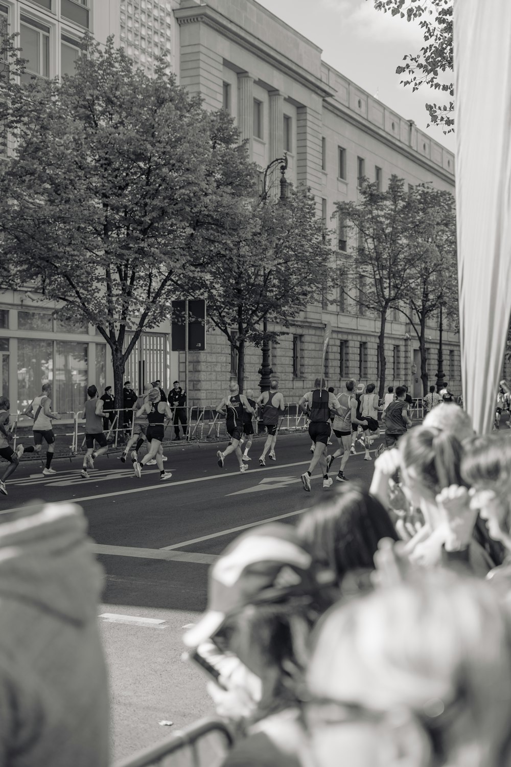 a group of people walking down a street next to tall buildings