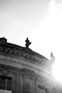 a black and white photo of a statue on top of a building
