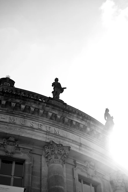 a black and white photo of a statue on top of a building
