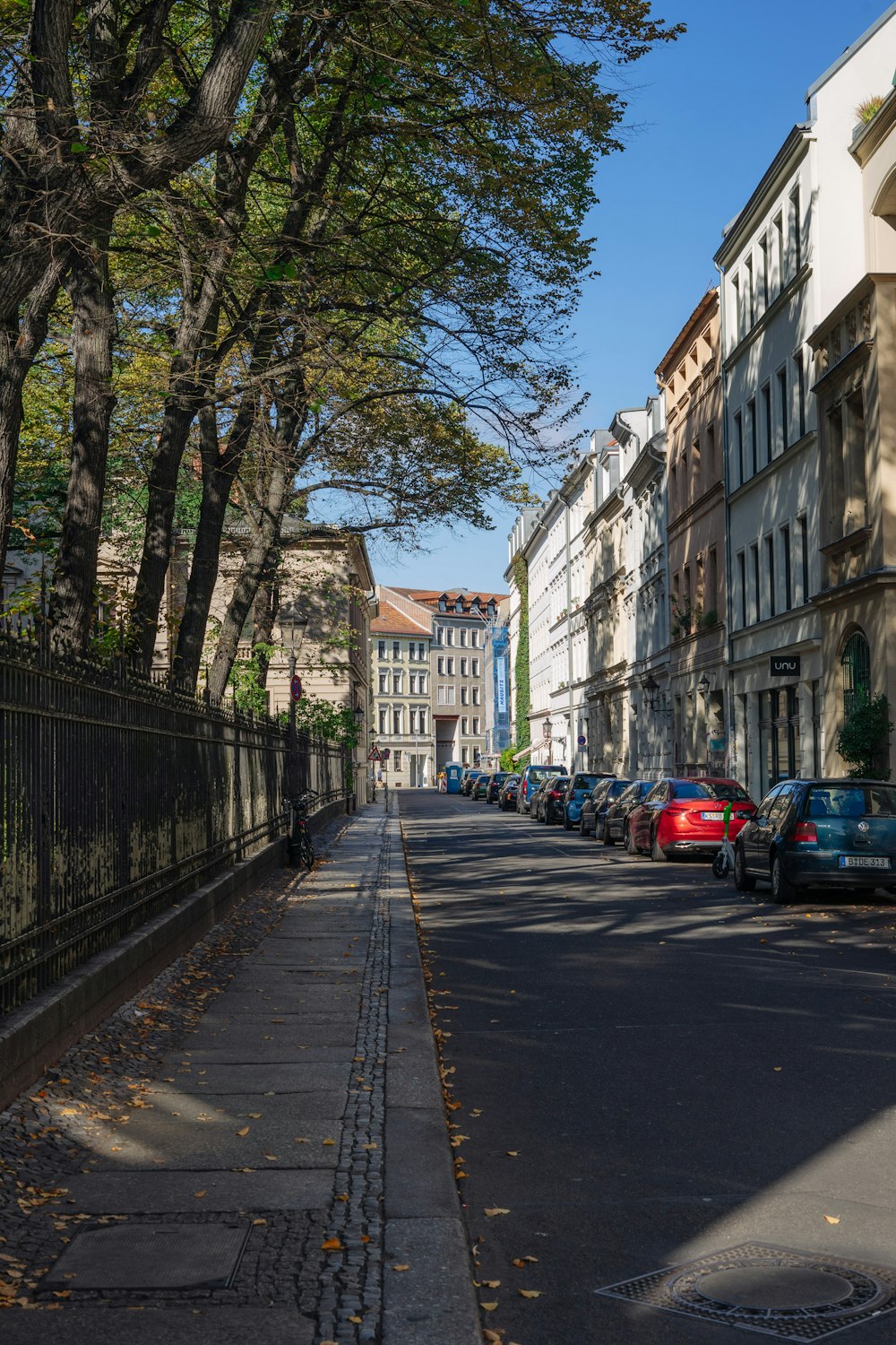 a street lined with parked cars next to tall buildings