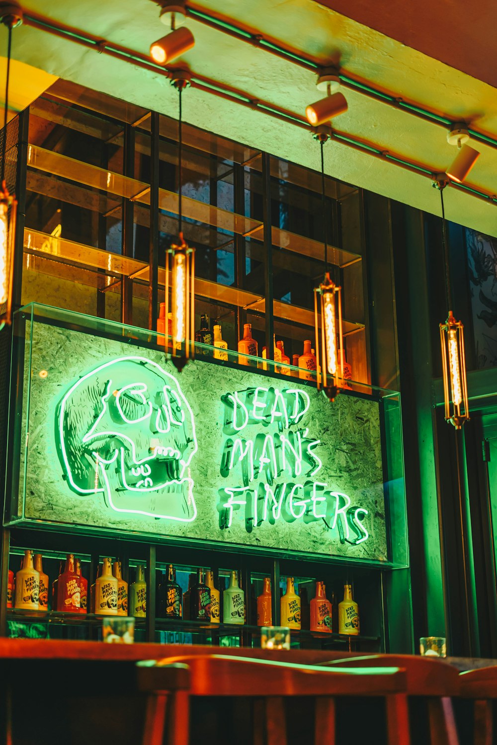 a bar with a neon sign that says dead man's fingers