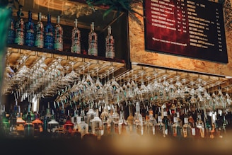 a bunch of wine glasses hanging on a wall